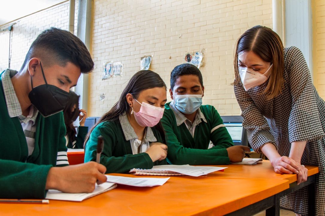 Docente con un grupo de estudiantes leyendo un texto CommonLit en PDF.