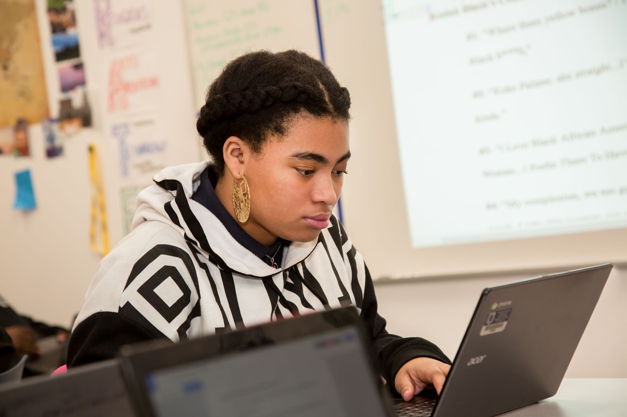 Teenage student works on laptop. 