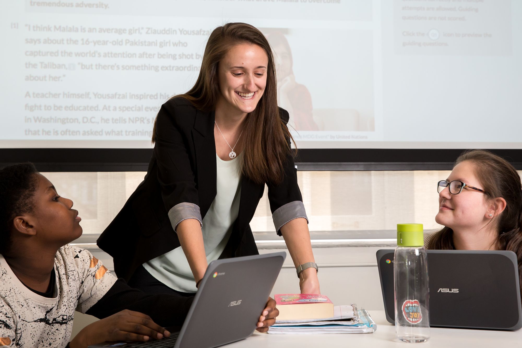 Teacher talks with two students.