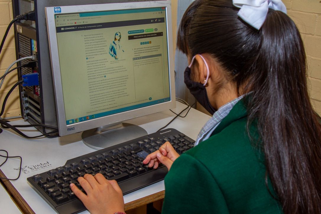 Estudiante trabajando una actividad de CommonLit en una computador en su clase.