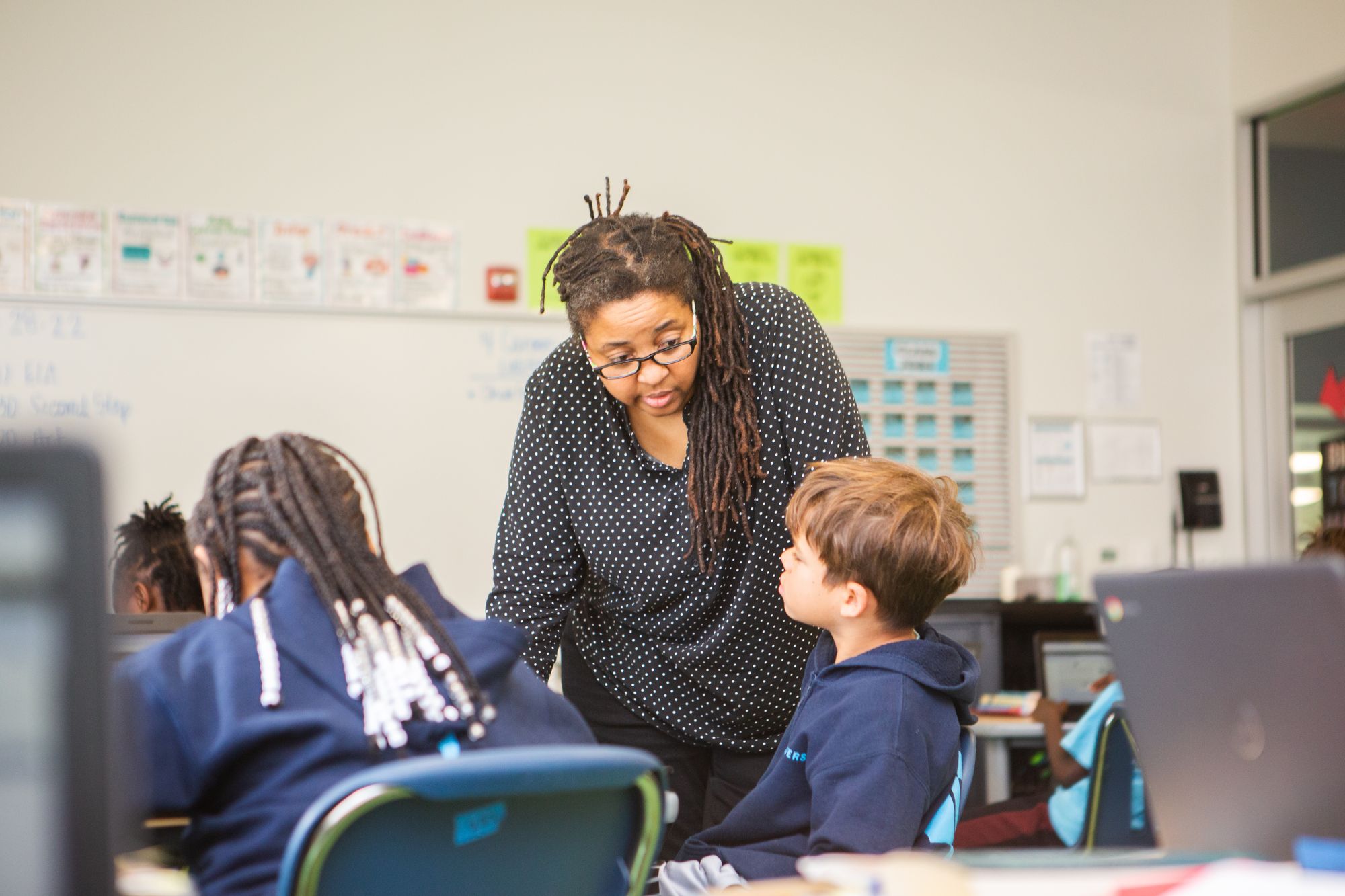 A teacher helps students with their lessons on CommonLit.