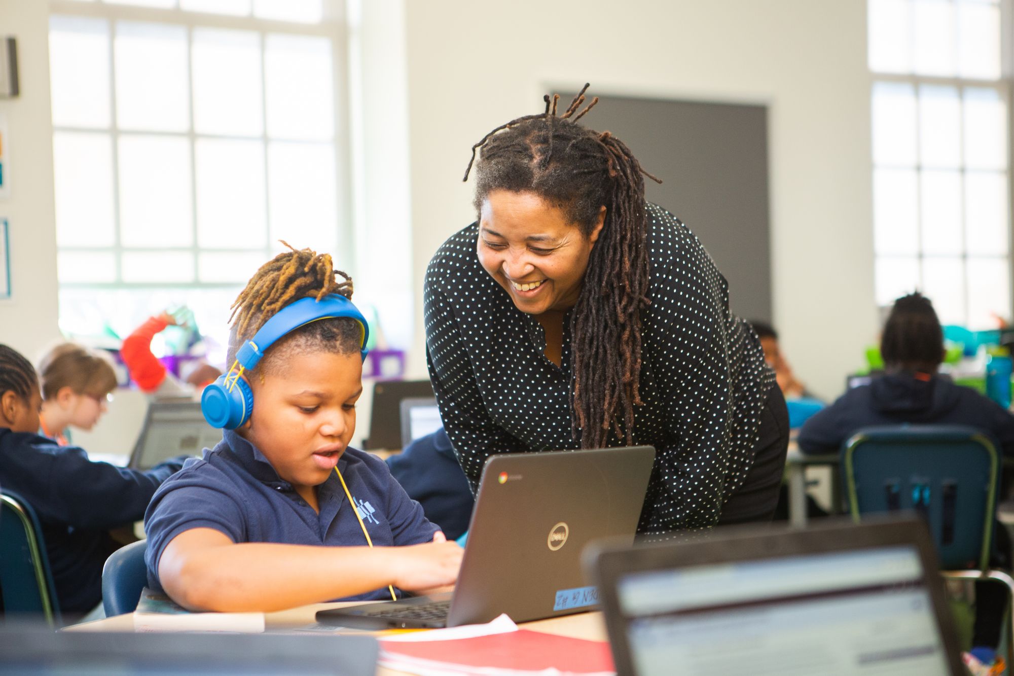 A photo of a teacher working with a young student on a CommonLit poetry lesson.