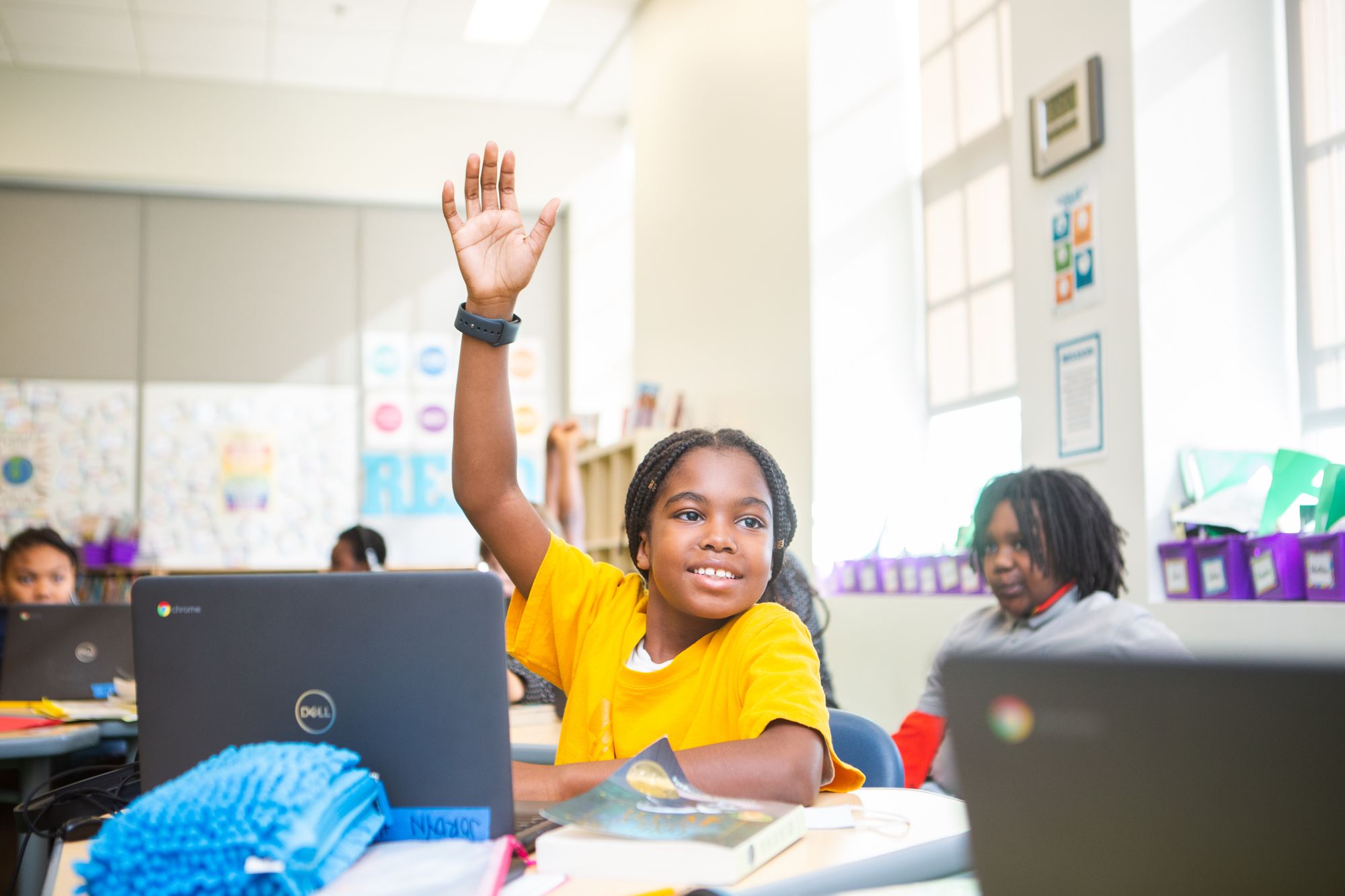 A female student raises her hand to share in class.