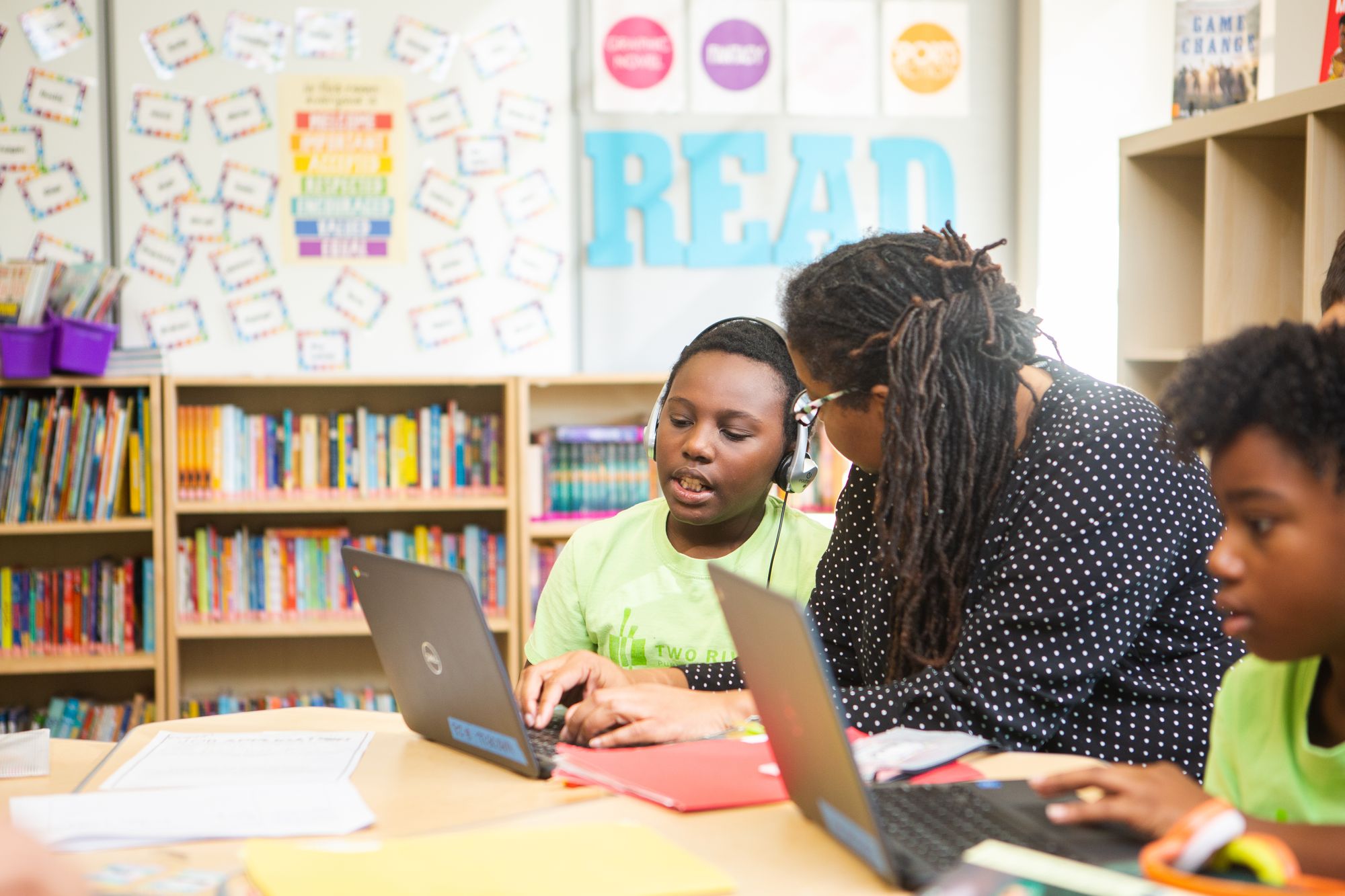 Teacher helps student with a CommonLit lesson.