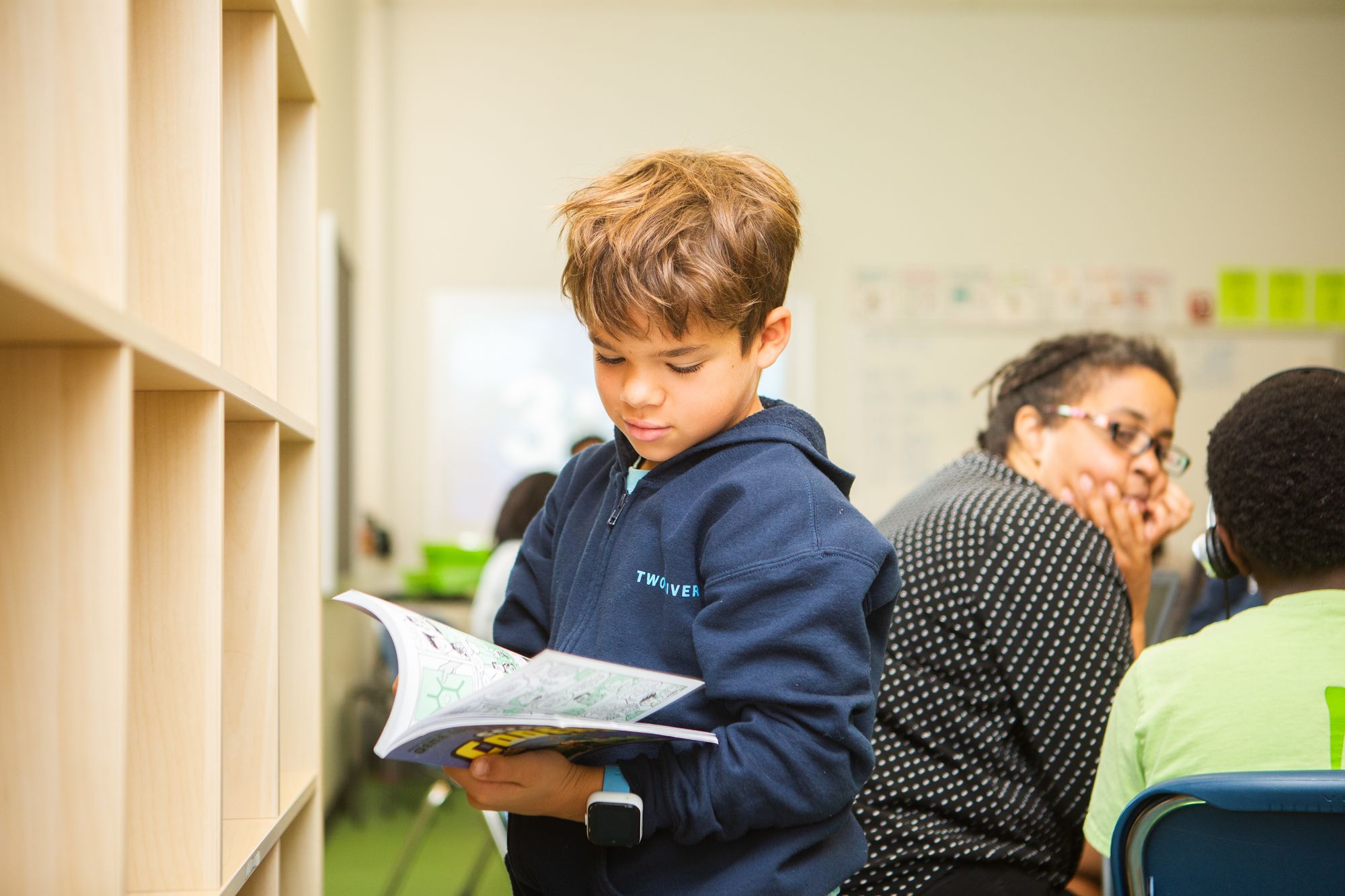 Boy looking down at his book in class