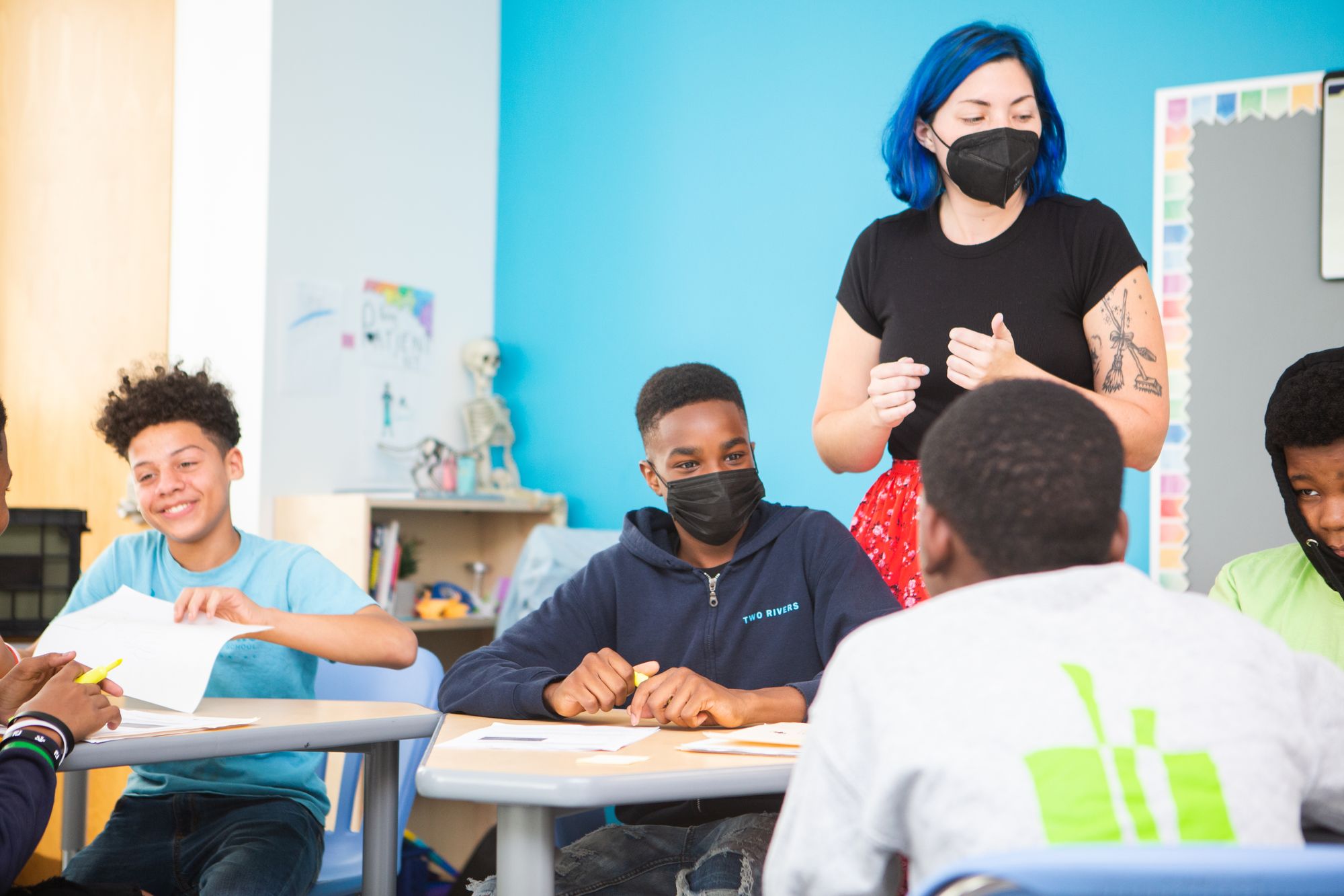 A teacher talks to a group of middle school students. 