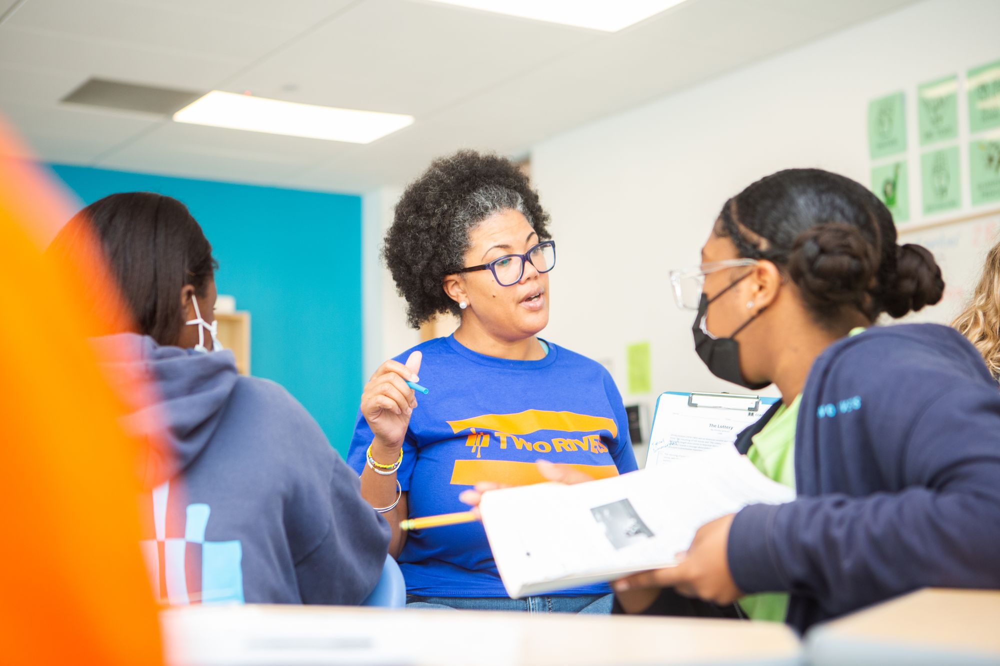 A teacher conferences with students.