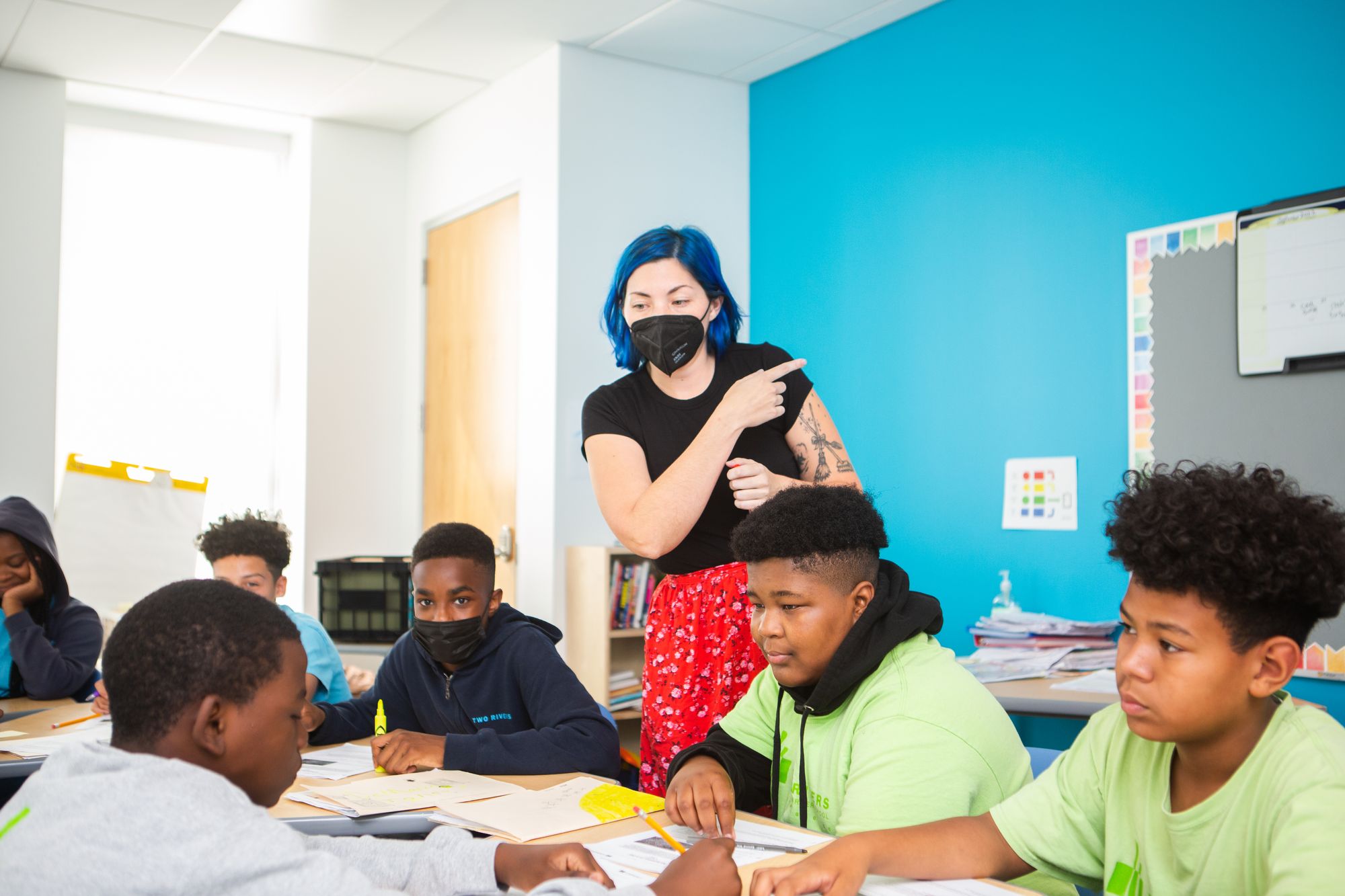 A teacher works on a CommonLit lesson with a group of students. 