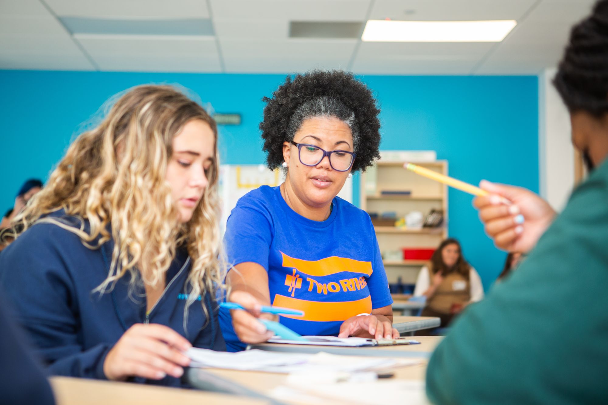 Teacher assisting student with school assignment