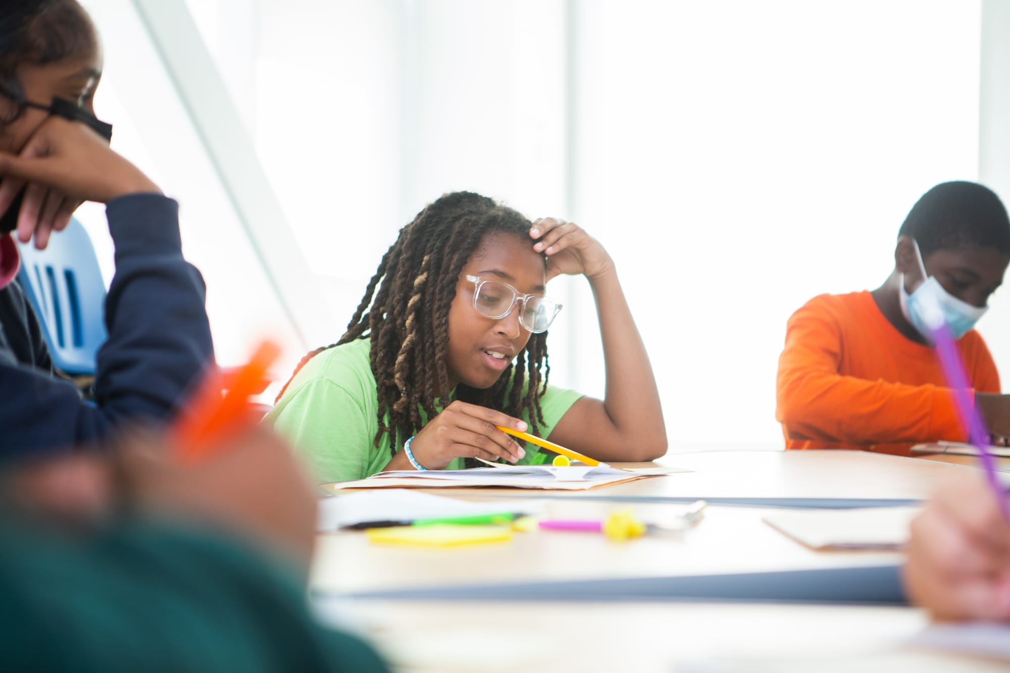 Student holding a pencil and looking over her school worksheet