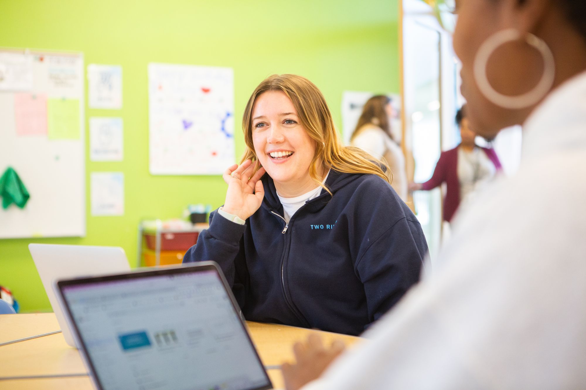 Teacher smiles looking at laptop. 