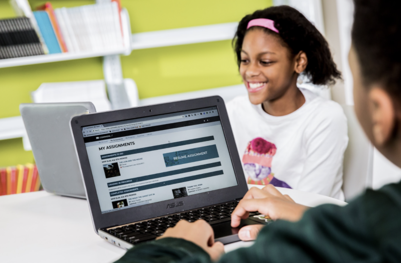 Girl smiles while working on laptop.